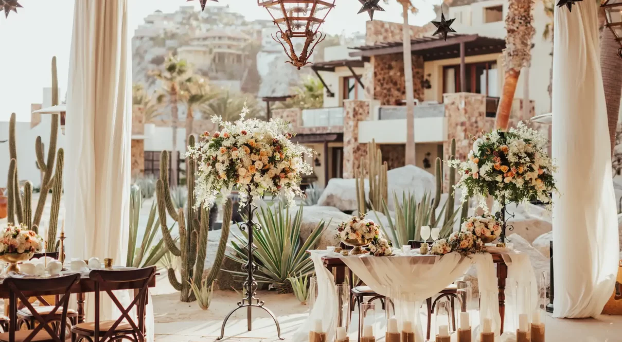 Outdoor wedding reception with floral decor, sweetheart table, and lanterns in a desert resort setting.