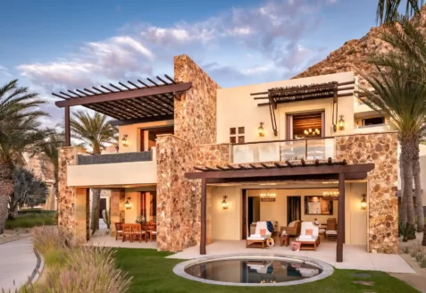 Two-story villa with plunge pool, pergolas, and mountain views in a tropical desert setting.
